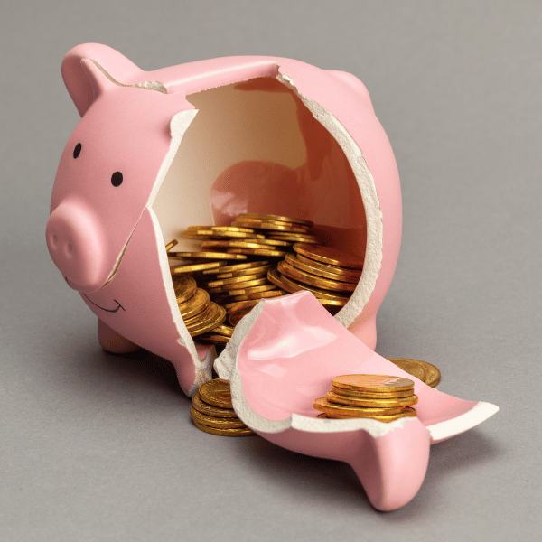 Broken piggy bank with money spilling out